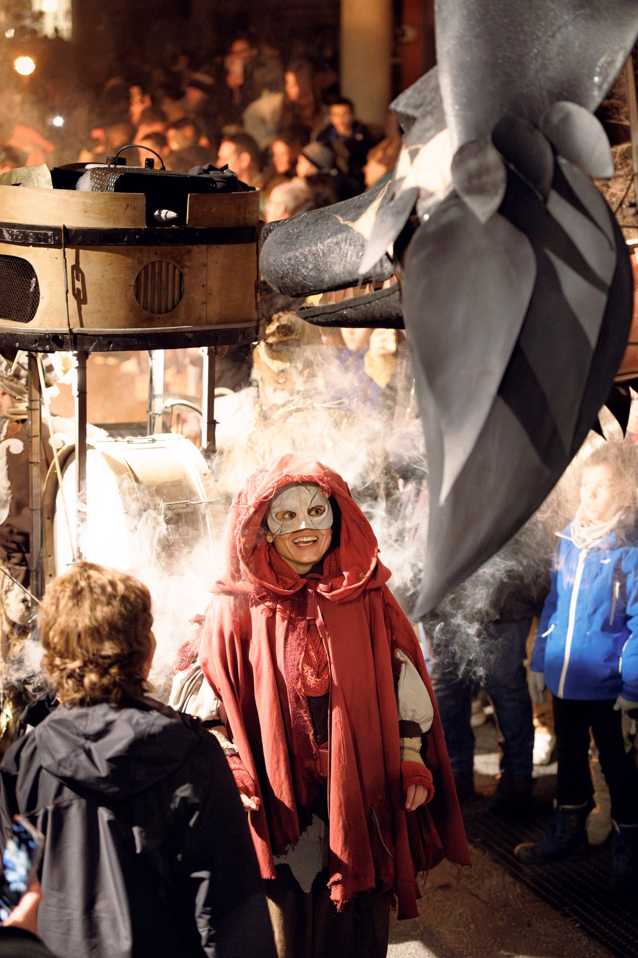 Personnage masqué à capuche rouge au milieu de la foule