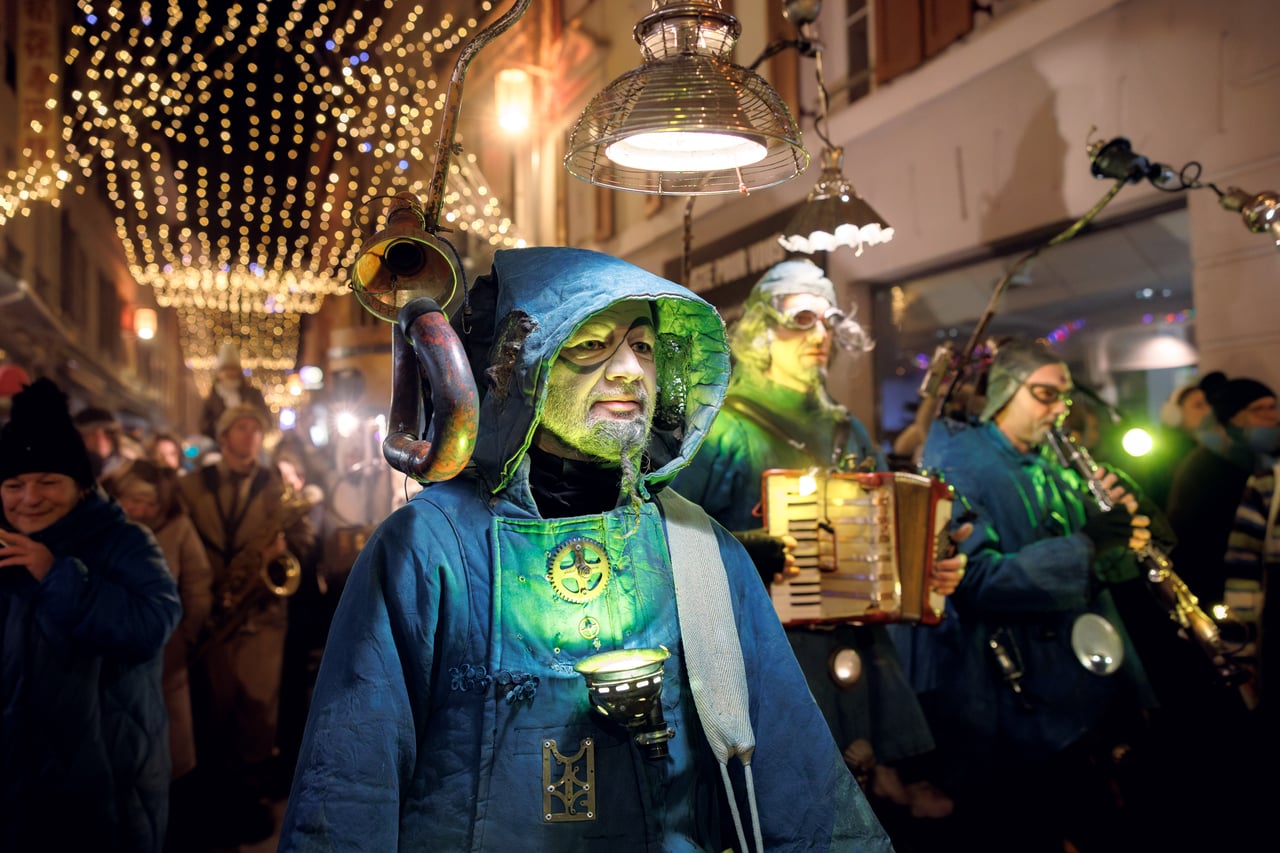 Costumed band musician under the street lights, Fabuleux Village des Flottins in Évian