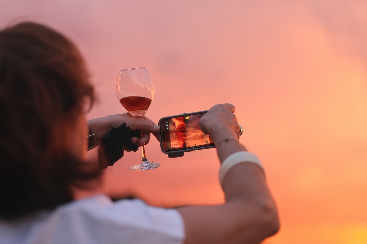 A guest photographs the sunset during a tournament evening