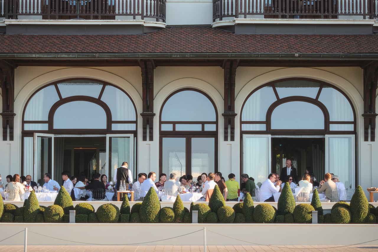 Dinner on the terrace in front of a grand hotel façade