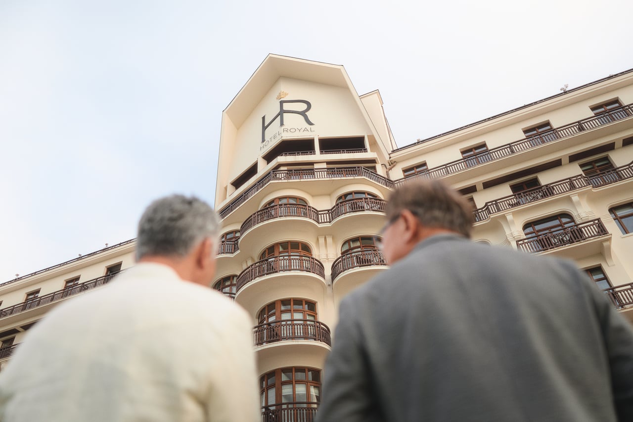 Two guests in front of the Hôtel Royal façade