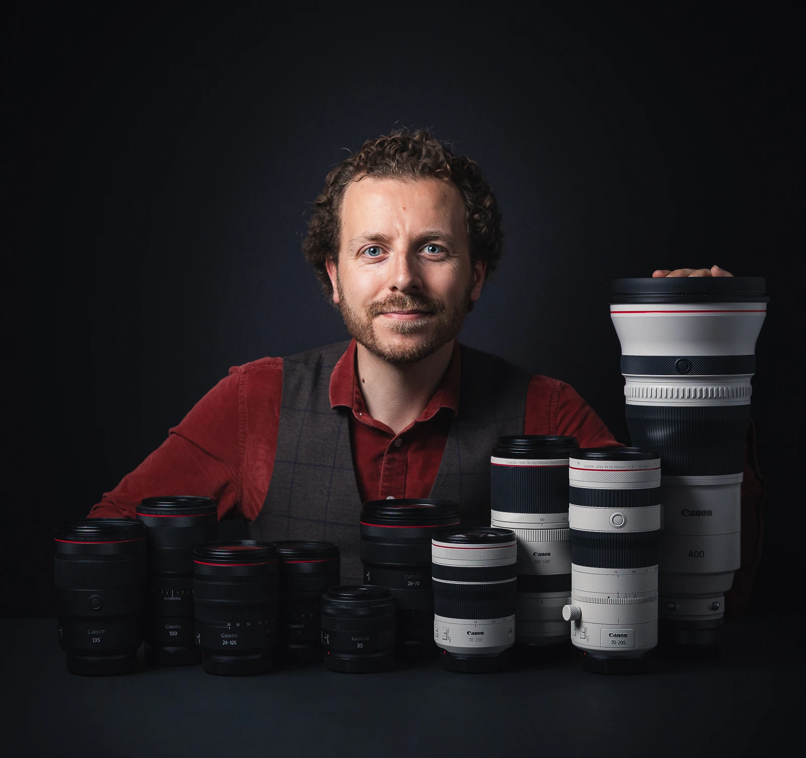 Autoportrait du photographe Rüdi Welter qui pose avec ses objectifs.